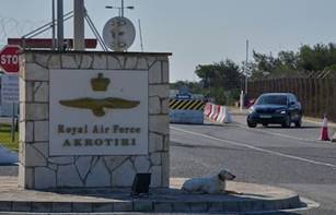 Un perro sentado ante a puerta principal de la base de la Fuerza Aérea Británica Akrotiri, cerca de Limassol, Chipre, el 2 de marzo de 2026